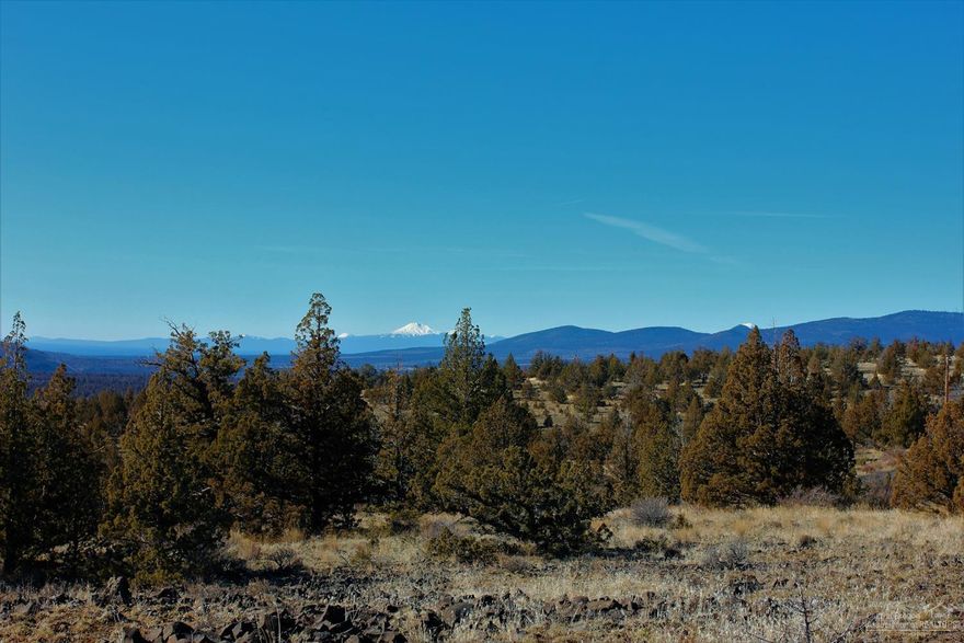 Located at the end of a cul-de-sac in a lovely gated community with approximately 7 miles of paved roads, septic approved, shared capped 2 party well, access to landlocked BLM through Phase I and public state ground through phase III, power is available. Beautiful views with peek a boo mountain views. Nicely shaped lot with large frontage. Corners are easy to find.