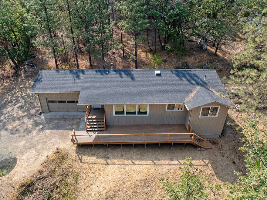 Completely remodeled home in the heart of desirable Applegate Valley! With a new roof, exterior & interior paint, HVAC, flooring, and lighting fixtures throughout, this home is truly move in ready and worry-free. Step inside the front door and you will be greeted with an open floor plan and abundant natural light. The kitchen is a culinary dream with quartz counters, custom cabinets, and top-notch stainless steel appliances - including a range / oven and microwave w/convection oven. The spacious primary bedroom offers a new vanity in the bathroom and the laundry room and guest bath feature custom cabinets. With wooded views out every window, you'll be surrounded by the beauty of nature. The wood stove with stone surround brings a cozy vibe and the new Trex deck is the perfect spot to enjoy your morning coffee. Only 1 mile to gorgeous Cantrall Buckley Park and the Applegate River and a 30 minute drive to Medford make this location ideal.