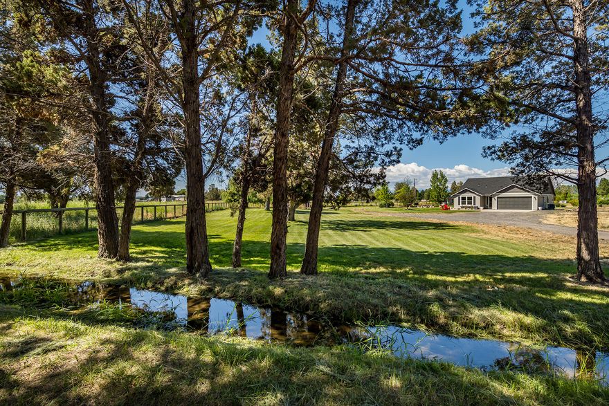 Desirable, private, fully fenced 4.92 acre mini-farm with a beautiful single level home and 40' x 48' shop. Home is recently upgraded throughout with new laminate flooring, fresh interior/exterior paint, new carpet in master, updated vinyl in bathrooms, and more. Property features large pond, Wi-Fi controlled irrigation pump, in-ground sprinklers on wi-fi controlled system, buried propane tank, loafing-shed, and automated watering raised garden bed. This turn-key property includes a hot tub with deck lighting, automated entry gate, renovated patio, and beautiful landscaping. Shop has concrete floor with 14' RV door and 10' vehicle door. Perfect for country living, optimized for modern rural lifestyle, ideally located between Bend and Redmond. Uniquely situated, this property provides privacy not found on much larger acreage.