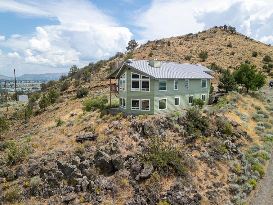 Welcome to your 20.79-acre private retreat w/ panoramic views in every direction—south to the Link River & Mount Shasta, west across rolling fields & forested hills, north & east to Mount McLoughlin & Stewart Lennox, all minutes from Klamath Falls. Watch hawks soar & mist drift above the valley, or unwind w/ epic sunsets & storm views from your vaulted-ceiling living room w/ a wall of windows & wood stove. The main level also features a kitchen w/ breakfast bar, walk-in pantry, covered deck access, two bedrooms (one with walk-in closet), & full bath. Downstairs: huge family room w/ wood stove, three more bedrooms, two full baths, office/flex space, laundry w/ utility sink. A 45x45 shop & oversized attached garage add extra value. Embrace nature, space, & comfort just 10 minutes from town, Moore Park, & Crater Lake Regional Airport. Rare, inspiring, & move-in ready!