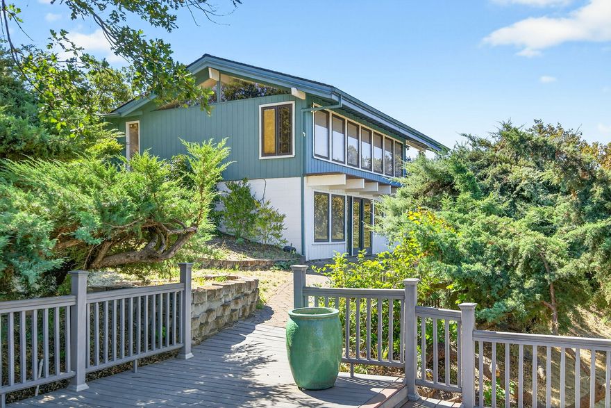 Custom-built home with stunning panoramic views of the Rogue Valley! Set back from the road for added privacy, this 3 bed, 2.5 bath gem features an open floor plan, rich hardwood floors, and floor-to-ceiling Pella windows that flood the home with natural light.  A newly installed A/C unit ensures year-round comfort. . The beautifully remodeled kitchen includes custom cabinetry, granite countertops, built-in refrigerator, and an Electrolux dual-fuel double oven range. Enjoy cozy evenings with wood-burning fireplaces in both the family and living rooms. The primary suite offers an updated bath with granite, tile, and fresh paint throughout the home. Outdoors, you'll find a 24x30 shop, greenhouse, irrigated gardens (MID), multiple decks, and plenty of space for entertaining or relaxing in nature. A rare blend of comfort, style, and breathtaking views!