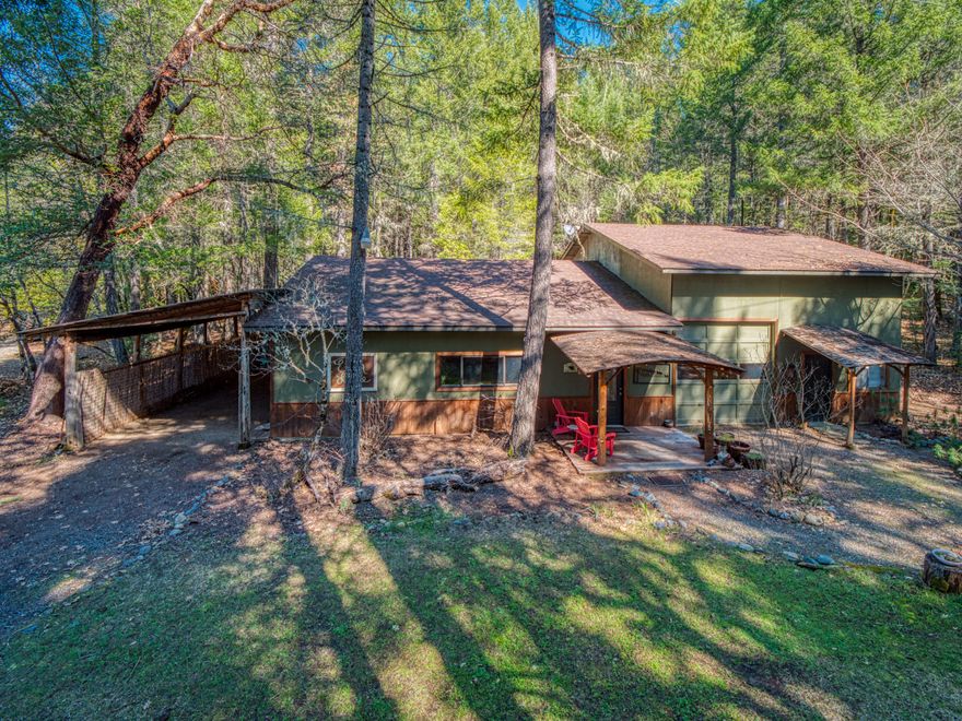 Sitting on just over 15 mostly flat usable acres adjacent to the Illinois River with private river access and backing up to BLM land - This unique 2,400 sq ft industrial style home features a wide open floor plan with soaring ceilings and an enormous vintage chandelier. Perfectly blending a warm homey feel with incredible practical uses. Cord wood style log wall, finished cement floors and a roll up door that allows for vehicle access into the main living area. Unload your U-Haul in no time - This home is a must see! This property features a one of a kind 200 sq ft guest treehouse which includes a private shower and toilet. Tucked behind the home you'll find a large, fenced and irrigated gardening area with 3 shipping containers. Owner has three parcels all next to each other and the seller is interested in selling all together or separately. Great opportunity for a grow or just a place to enjoy some peace and privacy. This won't last long!