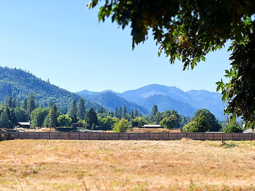 2+/- ACRE EFU PARCEL IS PRIVACY FENCED/CROSS-FENCED AND ACROSS FROM ROGUE RIVER Level, well-maintained EFU zoned parcel across from the scenic Rogue River is ready for your development ideas! This parcel is fenced on three sides and cross-fenced for additional privacy. The premium wood fence is a beautiful upgrade to the parcel layout. The tranquil parcel is complimented by a stunning Oak and an equally scenic mountain view. The majestic Oak provides welcome shade to an existing concrete pad. Be sure to take a moment to sit in the shade, admire the greenery of the mountain views, and plan how YOU would use the parcel. If you're considering agriculture, the property has EFU zoning and irrigation rights; prior parcel use included a hemp farm. Consider equestrian or livestock use...or park your RV and vacation at the Rogue River! The existing concrete pad indicates prior development; Buyer to perform their own due diligence inspection with respect to use or development of property