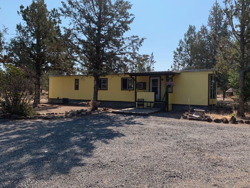 Very clean Manufactured home on pier blocks with partial home addition built on concrete slab. 1.86 Fully fenced acres on a corner lot, paved roads and just 15 minutes SE of town. Several outbuildings including a 24x30 work shop/garage with 220 power and concrete floor. Several storage sheds, well is in good working order with pump and wiring replaced a few years ago. Perfect horse property, there's a great area already for a small riding arena.  Standard septic system.  Home being sold as-is.  Please wear face mask when showing and follow current COVID guidelines.