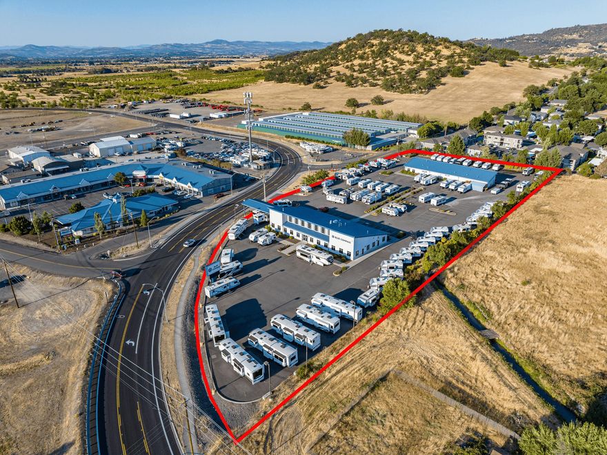 Exclusively presented for lease - 1600 Coker Butte Road, a highly-visible flexible property at the intersection of Crater Lake Avenue and Coker Butte Road. An iconic and well-known asset in north Medford, the former Hertz facility and current RV sales and service center is available for lease beginning 1/1/2026. Sited on a 100% paved and lighted 3.66 acre lot, the flexible property includes abundant outdoor display area, showroom/office building, and a dedicated shop. The clear-span steel-frame showroom enjoys expansive wide-open central core, private offices, kitchens, breakroom, storage and more. The rear shop enjoys (6) 10'x10' overheads, dedicated public lobby, kitchen and bathroom, and 6 service bays with 4 hydraulic lifts, individual gas heaters, in-slab drains and 16' max clear height. The modern, 2001-built buildings are efficient, and while ideal for an automotive-focused use, could be a fit for a wide variety of tenants. Contact the listing brokers for more information.