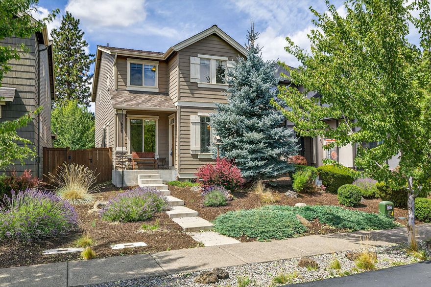 Ideally situated in the sought-after Bridges community, this meticulously maintained two-story home offers 3 bedrooms, 2.5 baths, and a thoughtfully designed open floor plan. The inviting great room features a striking stacked-rock gas fireplace, while the upgraded kitchen boasts stainless steel appliances, quartz countertops, backsplash, breakfast bar, and warm alder cabinetry. Upstairs, a versatile loft provides a perfect space for a playroom, home office, or cozy second lounge. The private side yard is ideal for outdoor dining and entertaining year-round. As a resident of The Bridges, you'll enjoy resort-style amenities including a pool, hot tub, playground, BBQ area, fitness center, indoor basketball/volleyball court, game room, and a clubhouse with a full kitchen, bar, and lounge for hosting events. Located just 10 minutes from downtown Bend and mere steps from the new 37-acre Alpenglow Park.