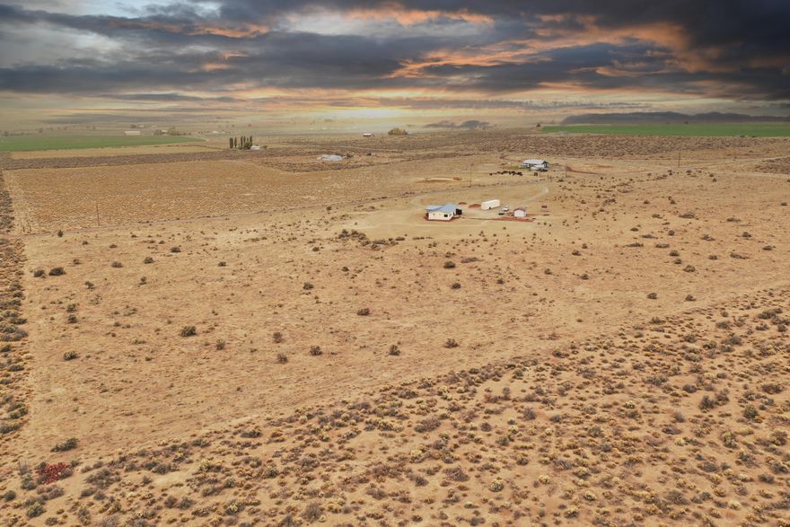 Enjoy the Sunrise and Sunsets from this beautiful home perched on an elevated private and peaceful spot overlooking the valley and mountain ranges just 100 yards off the paved main road. Incredibly clean and well maintained home with some nice upgrades such as a metal roof,  marmoleum tile flooring throughout the kitchen, laundry and dining area, new exterior paint, solid core fir interior doors, ceiling fans, propane fireplace for additional heat, jetted tub and upgraded carpet. There's also a full concrete slab underneath for clean easy access. About 20 acres of cleared land with underground sprinkler system already installed and RV parking that has full hookups. Close to BLM and Sand Dunes. This property is turn-key and ready to go, set up your viewing appointment before it's gone!