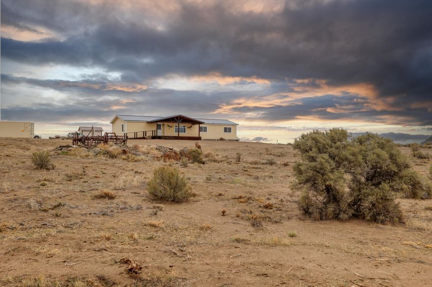 Enjoy the Sunrise and Sunsets from this beautiful home perched on an elevated private and peaceful spot overlooking the valley and mountain ranges just 100 yards off the paved main road. Incredibly clean and well maintained home with some nice upgrades such as a metal roof,  marmoleum tile flooring throughout the kitchen, laundry and dining area, new exterior paint, solid core fir interior doors, ceiling fans, propane fireplace for additional heat, jetted tub and upgraded carpet. There's also a full concrete slab underneath for clean easy access. About 20 acres of cleared land with underground sprinkler system already installed and RV parking that has full hookups. Close to BLM and Sand Dunes. This property is turn-key and ready to go, set up your viewing appointment before it's gone!