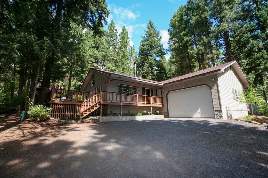 Beautiful, Quiet location just 20 minutes from town. Nestled in the trees is this lovely 2 Bedroom, possibly 3 with 2 full baths. Open floor plan with cathedral ceilings. Wrap around deck. Garage door is oversized and interior is sheet rocked with additional insulation. This property has an additional detached building built in 2011, lower level is a double door shop and upper level is a large studio/office or possibly a 3rd. bedroom. Chicken coop with fenced run. Landscaping is a zen garden in backyard with drip system to entire acre. River just minutes away. Wonderful Bike/ATV trails all out the front door. Very well maintained. Pride in ownership shows throughout. Seller is a Licensed Real Estate Broker.