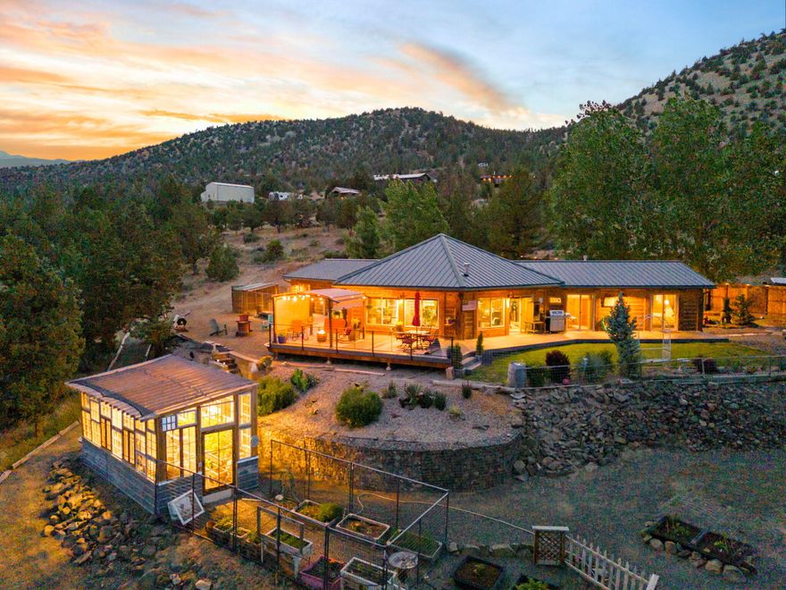 Perched above Prineville Reservoir, this stunning custom log home offers panoramic lake views and luxurious updates throughout. Fully remodeled with LVP flooring, quartz countertops, designer lighting, custom cabinetry, and a Thermador propane range. The chef's kitchen opens to a spacious living area with walls of windows to take in the view. The spa-like primary suite features tranquil lake views, a custom walk-in closet, tile shower, and double vanity. A split floor plan offers privacy with two guest rooms and a beautifully updated bath with clawfoot tub, tile shower, and quartz vanity. Step outside to a brand-new Trex deck with railing, a generous fire pit area, fenced garden, and greenhouse. The property also includes a detached 3-car garage, 20x24 shop, and 50-amp RV hookups. Sold fully furnished and move-in ready, perfect as a full-time residence, vacation getaway, or short-term rental opportunity. Don't miss this rare retreat with unmatched views!