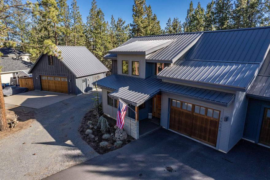 Stunning custom home on a large lot in a desirable neighborhood on the path to Mt. Bachelor, hiking, mountain biking, and the Cascade Lakes. Built with the utmost attention to detail, expansive vaulted ceilings in the great room and all bedrooms, a large open kitchen is perfect for any chef. A comfortable floor plan with the primary bedroom and office downstairs, 3 bedrooms and a cozy bonus room upstairs. The southern exposure gives plenty of light all year long and the ultra private, large backyard has that ''out of town'' feel and yet you're minutes from downtown and the Old Mill. Looking for garage space? This home offers an attached 2 car garage plus a detached 2 car garage/shop with a finished flex space above. Plus plenty of space to park your toys, campers, RV's, & vans.