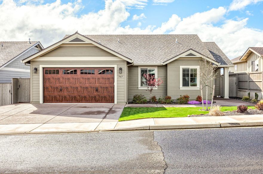 Wonderful Mahar-built, single-level home with unobstructed vineyard views in a vibrant 55+ community! This Earth Advantage Platinum home, just two years old, boasts an efficient open floor plan with high ceilings. The vaulted living room features a gas fireplace, hardwood floors, and picture windows showcasing stunning mountain views. The kitchen has stainless steel appliances, custom cabinets, and a dining area that opens to a spacious patio—perfect for indoor/outdoor living. The primary suite offers patio access, a walk-in closet, and a large en suite bath, creating a private retreat. Two additional bedrooms and a full bath provide space for guests or a home office. A laundry/mudroom leads to the two-car garage for added convenience. With quality construction, thoughtful finishes, and a peaceful setting on a quiet street, this home is a must-see!
