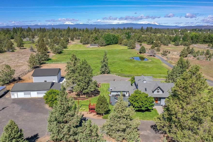 Mountain views from this gorgeous 5 acre property boasting a 2 stall barn w/ tack room and workshop, and 1300 sq ft shop on a separate meter with 14x11 roll up doors. Bring your animals, RVs, toys and equipment as this property will house it all! Newer SS appliances, large island, oak hardwood floors and sun-room round out the kitchen and dining area. This lovingly cared for 4 bedrooms plus office home has a spacious living area and bedrooms with lots of windows showcasing the property and views. Plenty of decking surround this house, making it perfect for entertaining and enjoying the sunset and flowering trees. This property is close to town but far enough away to feel like your own private sanctuary. New heat pump and humidification system added in 2017.