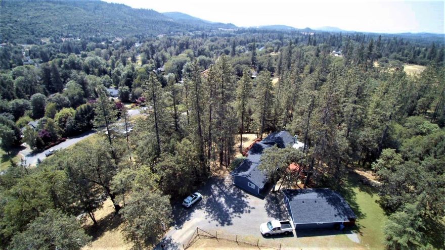 Forested end of the road privacy w-views! Beautiful rock fireplace next to the stunning wall of windows in the vaulted great room. Adjoining it is the newer kitchen w-natural edge granite counters & stainless appliances. 4 bedrooms, 2 baths; 2077 sq ft-newly remodeled & immaculate. New wood laminate flooring w-hand scraped finish, newer natural stone floors in both baths. Huge walk in closet in master. Sitting on over 1 acre w-nice flat back yard area w-room for a garden. New dog run behind the detached 2 car garage. Newly painted inside and outside (real cedar siding). Newer double pane windows. Front deck has a tree growing through it (on purpose). Back deck has a cover over half of it for year round dining. The property goes down a slope to a seasonal creek which has tons of potential for a natural sitting area among the trees or just leave it natural & enjoy the wildlife roaming through: turkeys, deer, etc. through this private acre. Plus just 4 minutes to Rogue River fishing!