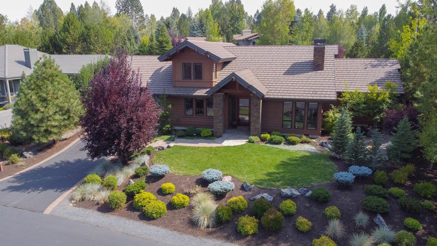 Experience this stunning home where Pacific Northwest architecture and contemporary design converge with natural surroundings just out the front door. Discover a 4-bed, 3.5-bath haven at Broken Top Community. Great room floorplan with large view windows, floor to ceiling stacked stone gas fireplace with custom wood mantle, hearth, and built-ins, vaulted ceiling, and Acacia hardwood flooring. Slab granite kitchen island with extra seating, counters with subway tile back splash, stainless appliances, and remote Hunter Douglas blinds. Thoughtful separation to the primary suite wing with spa like tile walk-in shower. Two bedrooms on the main with another bedroom, full bath, and media/ bonus room upstairs. Easy access to miles of soft trails. Enjoy the spacious grassy level above the covered outdoor living area with stamped concrete patio and hot tub. Naturally landscaped with some lawn. The heated garage is a 3-car tandem with custom built-ins. Visit: BrokenTop.com