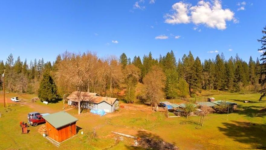 Beautiful, peaceful 12+ acres with pond, creek and large greenhouse. 3/1 home with vinyl windows and wood laminate floors overlooks the pond. 1000 sf shop has been partially converted to a studio apartment with loft, full kitchen, full bath, propane stove, on demand water heater, electric fridge and washer with propane dryer.