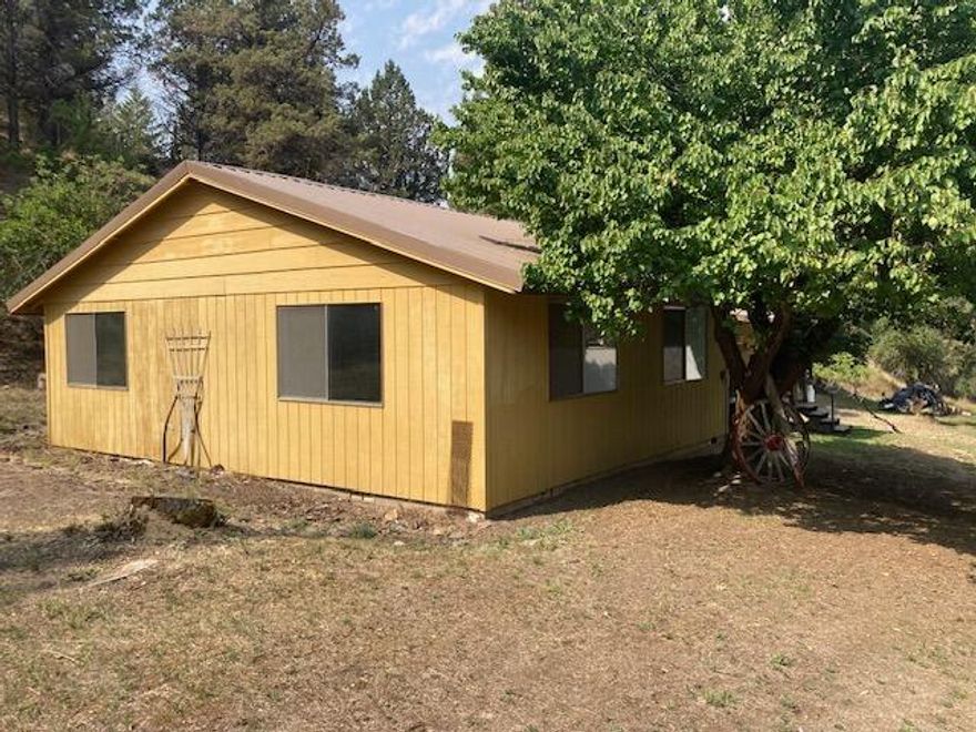 PRIVATE LOCATION NEAR CANYON CITY!  Quiet country setting, home on .80 of an acre, 1424 sq ft home with 3 bedrooms and 1.5 baths, all wood kitchen cabinets with fridge and stove, large living room with woodstove & ceiling fan, baseboard heat, carpet, large utility room/main bathroom, metal roof, separate pantry building, shade trees, fruit trees, gravel driveway, plenty of room for a garage and or shop.   $238,000 #1125
(very motivated seller will entertain all offers)