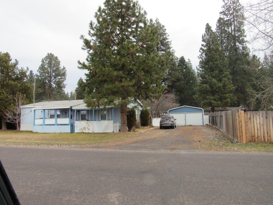 Great home in a small community close to both schools. 3 bedroom 2 bath manufactured home. Back yard all fenced . a couple of nice pine trees for shade.  Front and back has a nice covered deck or patio. Home has a certified wood stove. Most appliances are fairly new and will stay with the sale.
