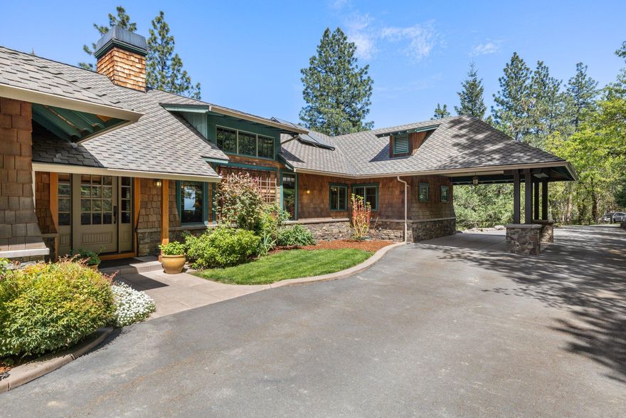 This gorgeous Pacific Northwest Craftsman home in a parklike setting welcomes you with exquisite craftsmanship and style. The vaulted ceiling in the great room creates a dramatic sense of space. The stone fireplace invites you to linger, while abundant wood-clad windows frame peaceful views. The spacious kitchen has a cooking island/breakfast bar, upscale appliances, stone countertops and custom fir cabinets. An expansive deck off the living area beckons you outside to enjoy panoramic views of the woods, valley and Table Rock. The main-level primary suite has a luxurious tiled bathroom with jetted tub. A butler's pantry, office and half-bath round out the main level. The lower level, with two additional bedrooms plus full bath, has a separate entrance. Car buffs will love the 3-bay attached garage, including a mechanic's bay & 220 power, and the detached RV garage. The fenced garden, greenhouse, small animal stalls and corrals complete the country living dream.