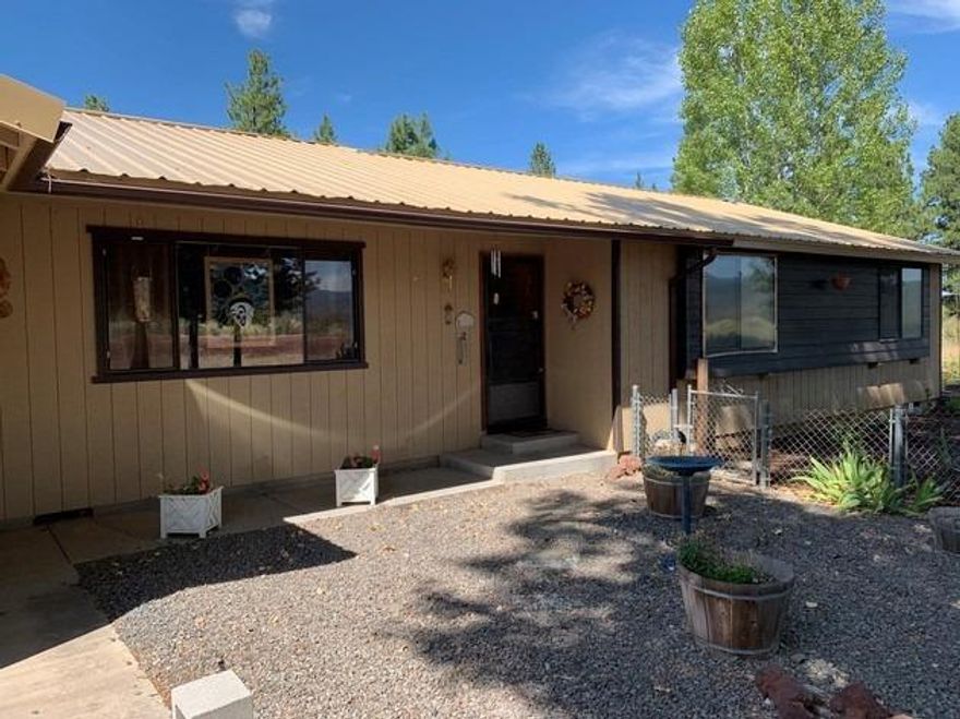 Single owner home featuring 3 bedrooms and 2 baths with an attached two car garage. Beautiful newer fiberglass door welcomes you into this home with laminate floors throughout. The certified wood stove will keep you cozy in the winter. Fully fenced back yard with in-ground sprinklers, apple & cherry trees and views of the lake. Low Maintenance front & side yard with a nice patio for dining al fresco. There is an additional garage/shop/barn to keep additional vehicles/work space/animals. Whatever suits your lifestyle. There is plenty of RV parking too! new septic. VA ready.