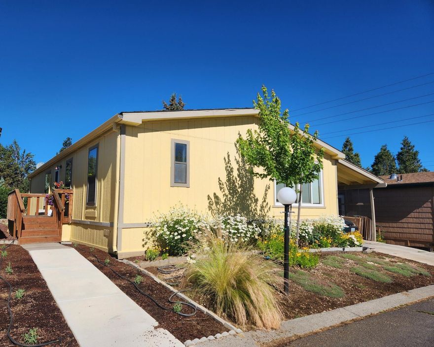 Welcome home to Suntree Village, one of Bend's finest 55+ parks. This home is 1320 sq ft, has 3 bedrooms, and 2 bathrooms, a Living room and Family room with vaulted ceilings, lots of windows and new wide plank vinyl flooring, a nice kitchen with new counters, sink, backsplash and stove, all appliances are included, large primary suite with large closet, and good separation from the other rooms, large utility room with stackable washer/dryer and a pantry. A Studio with window, desk,  electricity and carpet. A beautiful backyard to relax in. Also, Heat Pump, Carport, Storage unit.  All in walking distance to The Larkspur Community Center where you can swim and exercise. Space Rent is $647.00 mo. includes water/sewer, trash, and use of the Clubhouse.