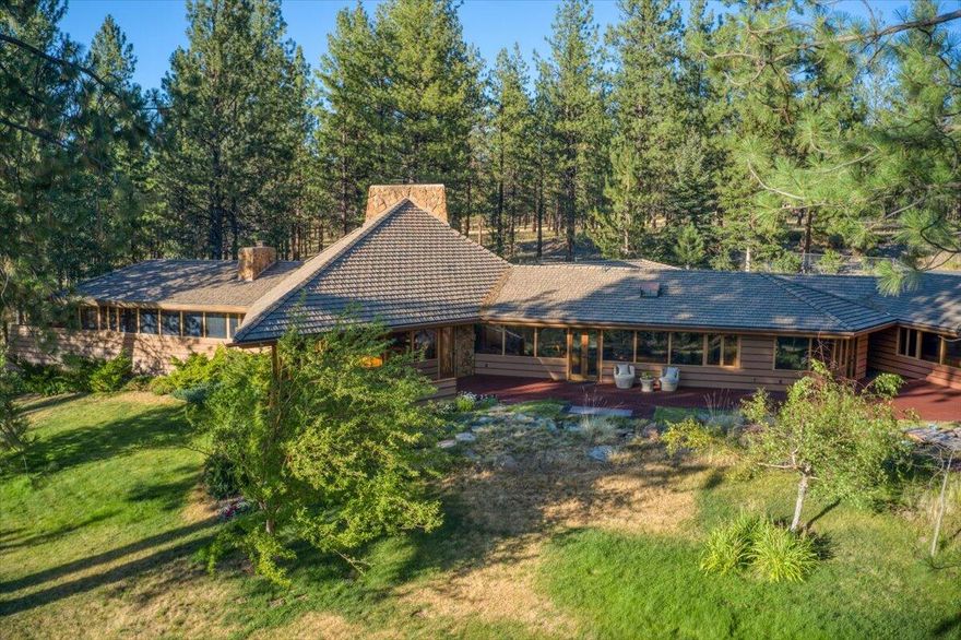 Stunning mid-century-style architectural masterpiece designed by Frank Lloyd Wright apprentice Milton Stricker. Located on 2 ½ acres in the premier equestrian community, Cascade Meadow Ranch, in Sisters, Oregon. Ranch amenities include secure gated access, community clubhouse, tennis courts, horse stalls, paddocks, indoor and outdoor arenas, and more. Every room embraces the outdoors: mountain views, a babbling brook water feature, expansive lawn, and landscape. This single-level open concept home features 3 bedroom suites, 2 fireplaces, family room, kitchen with high-end appliances (plus a steamer, warming drawer, and espresso machine), office/studio, wine cellar, indoor endless pool & dry sauna with shower, sunroom, laundry, 3-car garage + 2nd garage/workshop. A dramatic light fixture with a Cascade Mountain design motif transverses the great room vaulted ceiling. Constructed with clear cedar walls, mahogany built-ins, pecan floors, and Oregon Salishan stone.