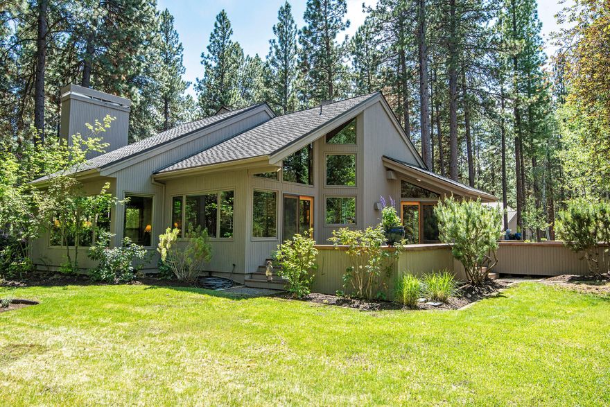 This light and airy Northwest contemporary home is located in the desirable East Meadow section of BBR. Quaking Aspen, Ponderosa Pines and Vine Maples plus a cascading water feature provide a beautiful and tranquil setting on this one acre lot. An open floor plan with vaulted clear Alder ceilings, hardwood and carpeted floors and handsome masonry create a stunning and comfortable home.  The master suite on the main level has built-ins, a large soaking tub, shower, double sinks and a walk-in closet. The kitchen has Corian counters, an antimicrobial low maintenance surface.
The upstairs has two bedrooms, a full bath, a cozy yet open loft lined with book cases. A spacious finished attic offers storage galore. The over-sized two car garage has floor to ceiling cabinets, a workbench and wood-burning stove. A must see property! Call today to schedule an appointment.