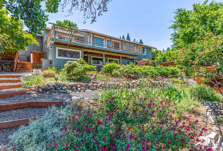 Spacious view home with elaborate Asian-inspired landscaping sited on nearly a third-acre lot above the Boulevard near Asante Ashland Community Hospital. Fully fenced private backyard features stone terracing and pebbled footpaths, pond and meandering stream, charming wooden bridges, covered meditation area, vegetable garden with raised beds, along with three storage areas. The home's main level has a front courtyard with access to the informal dining area and adjacent kitchen, living room and formal dining with sliding glass doors to a 488 SqFt deck, master bedroom with full ensuite bathroom, additional bedroom, and 2 car garage. The lower level features a third bedroom, full bathroom, bonus room, sauna area with shower, large media room with surround sound, and sliding glass door to a stone patio and workshop space under the under deck. New heat pump April 2021.