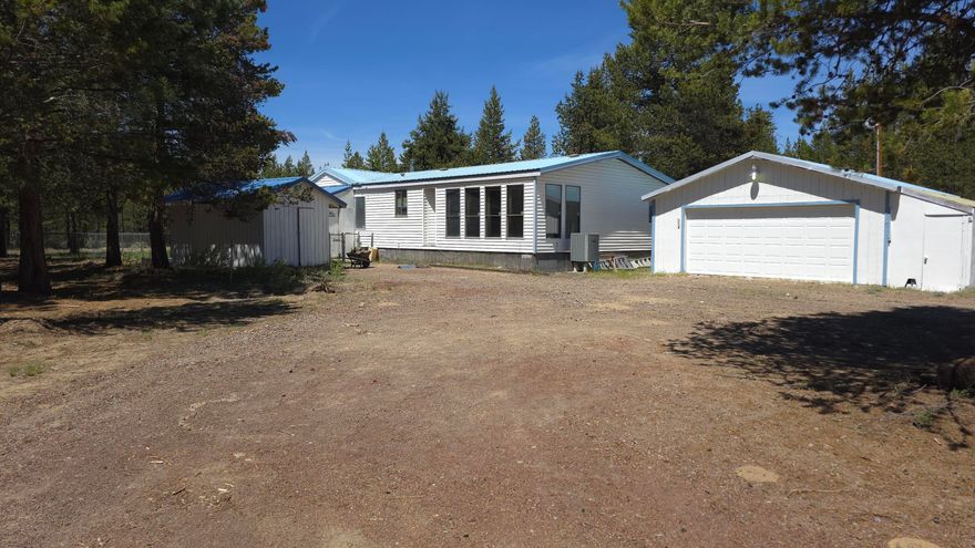Lo Lazy River South, this 2-bedroom, 2-bath home offers both comfort and functionality on a private acre. The floor plan provides privacy, with the primary bedroom and second bedroom separated by a generous living area. 

Updated flooring, formal dining area welcomes gatherings, living room and family room  have large windows that flood the home with natural light, creating a connection to the serene outdoor surroundings. 

Stay warm during cooler months with a wood stove, complemented by a covered wood storage area for added convenience. Laundry room with room for extra storage. Detached two-car garage provides ample storage and parking, all situated on a paved road for easy access. Backs almost 80 acres of private land giving a great sense of privacy.