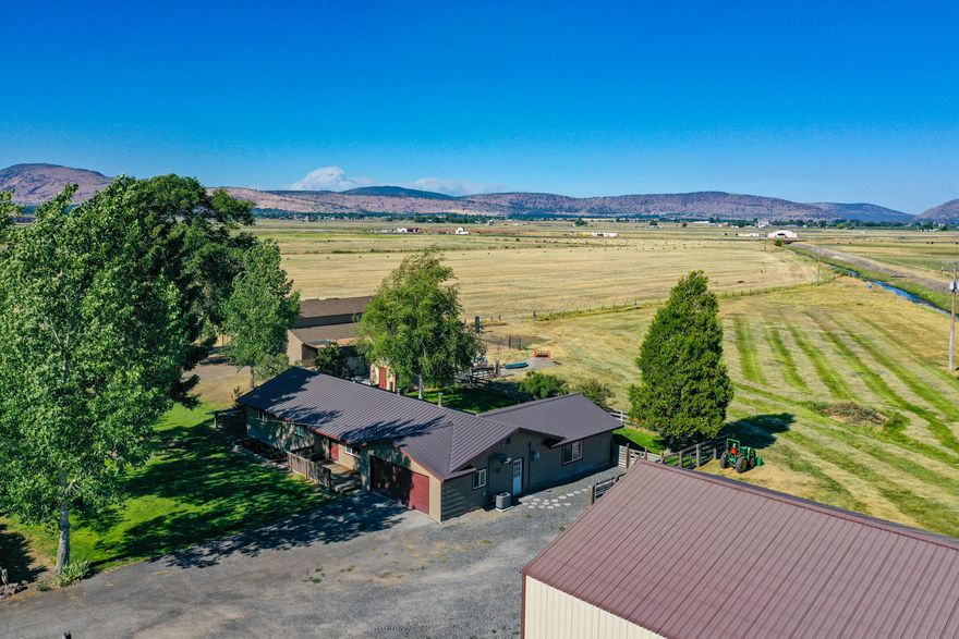 This 1,918 sqft home is in a beautiful setting with panoramic basin views and mountains as a backdrop!  Fantastic 29.57 acres country location and only a few short minutes to town.  Enjoy the 3Bed/2.5bath home with the wide open space of the great room, recently updated with extras such as a high end water filtration system with new fixtures. The patio out back is a lovely place to soak in the newer hot tub and take in the views. The opportunities are abundant with this property that is equipped with a large 1920 sqft insulated shop with 110/220 power and a pellet stove, horse barn with electricity and water, greenhouse with a fenced garden, 25 acres of KID irrigation and all the irrigation equipment is included!