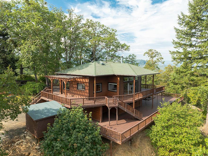 One-of-a-Kind Rural Home & Property with STUNNING Views located just minutes from Town! With 4 Bedrooms & 2 Full Baths, this Log-Sided Home has room for all your Living Needs! Enjoy a Spacious Main Living Area that offers a Nice Country Kitchen with Stainless Appliances, Dining Area, & Large Living Room with Huge Windows & Woodstove. The Distressed Hardwood Floors & Tongue & Groove Wood Ceiling add a sense of Comfort. 4 Bedrooms, 2 Well-Appointed Full Bathrooms, Huge Mud Room, Utility Room, Plenty of Storage, Several Built-in Features. Woodshed, & Shop/Craft Room! The Stunning 360 Degree Views are the real star here. It's like living in a Lookout Tower, only much bigger & with more Amenities! The Massive Two-Level Wrap-Around Deck with Hot Tub allows you to take in All Aspects of the Valley, Mountains, & City. Property is Nicely Landscaped, with Plenty of Parking, & has an Attractive Water Feature. Huge Graded Level Area a Short Distance from the Home is ready for your Dream Shop!