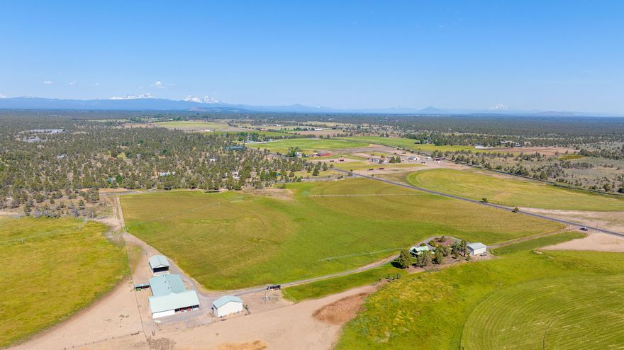 HUGE PRICE REDUCTION!!! Tremendous value. This Central Oregon small ranch, located just east of Bend, Oregon is an outstanding country estate! Currently set up as a horse property & small hay operation, it's the perfect setting for any horse lover, farmer, or small cattle operator. This is an excellent equestrian property featuring an open-span indoor arena with 9 horse stalls, & two tack rooms. It also features a large RV shop, 2 hay barns, 33 acres of COID irrigation, 3 pivots planted in orchard grass, which produces a nice hay base for your horses & cattle, an irrigation pond, & beautiful Cascade Mountain views. The handsome log home has been beautifully constructed with custom hand-scribed 15'' diameter logs. The interior walls have a modern post & beam feel with sheet rock, giving the home an open & welcoming appearance. The home features 3 bedrooms, 2.5 bath, large office, soaring vaults, French doors, master on the main level, bay window, wraparound decks, & so much more!