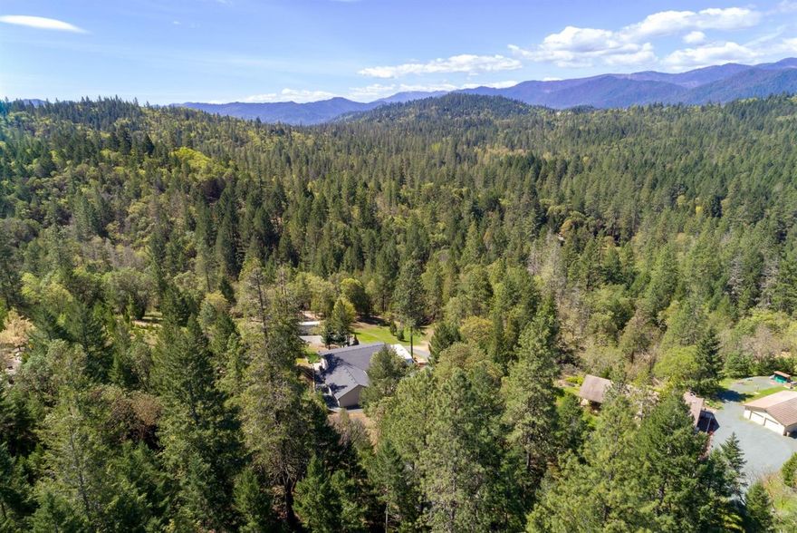 Sitting atop a 5 acres is this immaculate single-level Woodruff built home. From the new deck, listen to the seasonal creek, or venture through the property on one of the newly added trails, perfect for walking, horseback or motocross. The backyard is ready for you to take in the mountain views by the fire pit, fly down the 200' zipline, or build your dream shop on one of the laser-leveled pads. Inside find an equally immaculate home. The open floor plan and vaulted ceilings showcase views; the large kitchen is perfect for entertaining and the split floor plan provides privacy for the large master, with his/hers closets, large master bath, and a slider to the back deck. The home features ample storage, large laundry w custom counter, and a newly finished 3 car garage with workspace and 2-220 amp panels, with RV hookup outside. Newer heat pump, 50 year roof and more. Located just off Azalea Drive, this home is ideal for someone looking for for peace and perfection just outside of town.