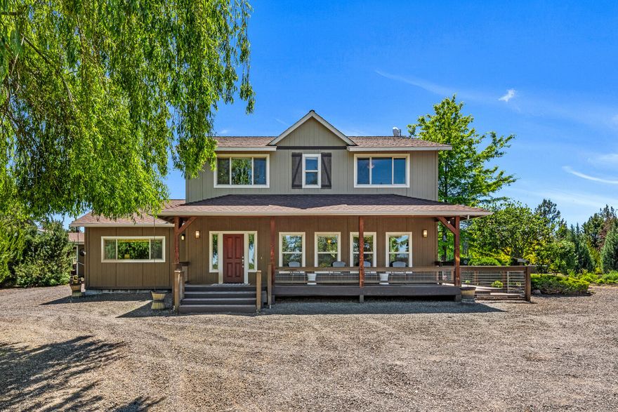 Discover this perfect hobby farm just outside Bend! This one of a kind property features a beautiful farmhouse, barn/shop with 4 stalls built in 2021, a round pen, arena, and two fenced pastures. The home boasts a welcoming front porch and energy-efficient features. Inside, the open floor plan includes solid craftsman birch flooring, a cook's kitchen with island seating, high-end SS appliances & custom knotty hickory cabinets. The dining area has a cozy corner fireplace. The family/bonus room includes a wood-burning stove. Upstairs, you will find 3 bedrooms & 2 full baths, including a primary suite with engineered bamboo flooring & a heated floor in the primary bath. The custom detached garage/shop includes four bays, a 220V outlet & workbench. The property is landscaped like a park with a pond & private paver patio with a firepit & hot tub, offering breathtaking views of the Cascade Mountains. Manufactured home on property is of no value and used primarily as storage.