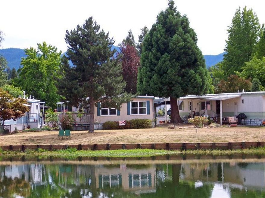 Lakeside Retreat in Rogue Lea Estates! This double-wide mobile home is waiting for you. It features 2 bedrooms, 2 baths, a nice kitchen w/appliances, a handy built-in dining room hutch & a good-sized living room all on the lake. There are views of the mountains as well as of both North Lake and South Lake from your front windows or from the great deck and yard. New roof & double-paned windows, nice large closets in both bedrooms & there is a pantry just outside of the kitchen. How can you go wrong with this price? Located in Rogue Lea Estates with a space rent of $535/mo including water, sewer & trash. There is an active Clubhouse with Bingo, Bunko & monthly pot-luck dinners. Most important is the convenient location close to everything you could need or want including the local hospital. Come take a look & make an offer today!