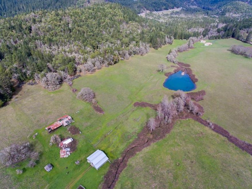 Opportunity abounds on this 80 acre Exclusive Farm zoned property. Previously used as a cattle and horse ranch, there is plenty of room and water for all your new adventures. Close to the I-5 exit in Sunny valley makes it conveniently close to Grants Pass and its amenities. Quaint 3 bedroom 1 and 1/2 bath farm house, and a 2nd legal home (manufactured holding home site) sit at the foot of the property overlooking roughly 50 acres of sunny,south facing pastures. Water rights from Salmon Creek & large pond registered with the state provide irrigation. Pond is registered to hold 6.5 acre feet of water (2,118,031 gallons). Property also features a 40 ton hay storage barn (per seller), 4 stall horse barn, and a detached 2 car garage. Property also has approximately 30 acres of merchantable timber. All information deemed reliable but not guaranteed and buyers to perform their own due diligence.