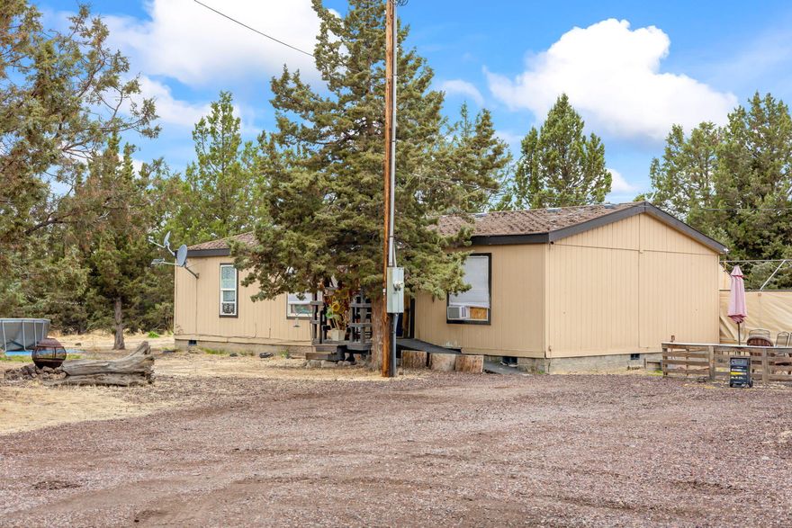 Welcome home to this 3 bedroom 2 bath 1993 home on 1.88 acres in PLA2. This quiet, safe community offers mostly paved roads and access to BLM for trails, riding, or exploring. This property is located on a private street nicely situated with some fencing, trees, storage buildings, and detached 800 sq ft garage/shop.
Fenced area for farm animals, small garden and lots of parking. Private well and standard septic system. Home has a great layout with 2 bedrooms on one side and the primary on the opposite side. Open concept living with updated laminate floors. Come take a look at all the possibilities this property has to offer.