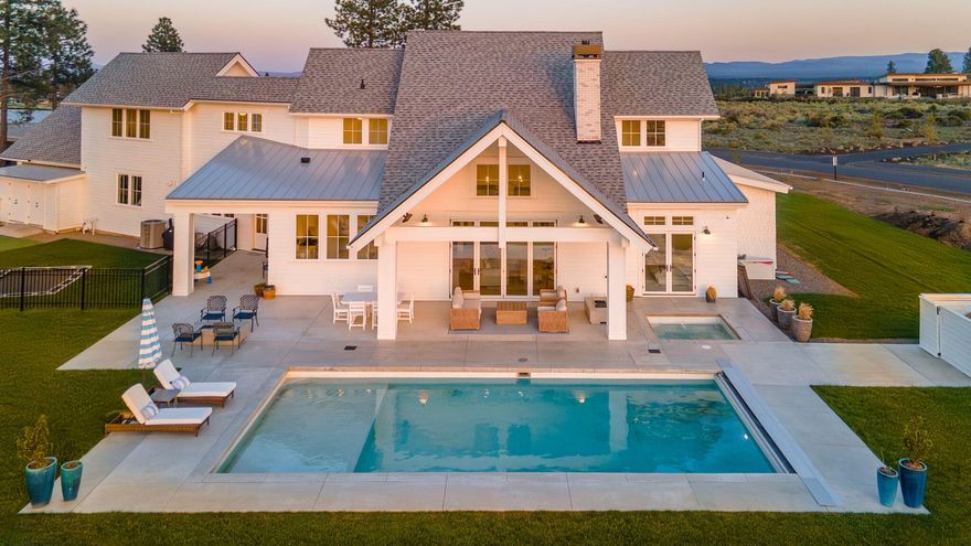 A perfect blend of traditional charm and contemporary elegance, this modern farmhouse is bathed in tones of fresh white inside & out for a truly striking effect. Here, cozy living spaces punctuated by high-design finishes give way to expansive windows offering panoramic views of the Cascades from nearly every angle. On the first floor, the great room and kitchen open to the sunny back patio via a paneled folding door. The kitchen is punctuated by a large island, beautiful Blue Star 8-burner range, double oven, butler pantry and entertainment bar. A first floor primary, two additional bedrooms, private office and spacious mudroom lend versatility and charming touches, such as a schoolhouse drinking fountain, dutch doors, beadboard, built-ins and more. Upstairs, two additional beds & baths give way to a large bonus space. Enveloped by the surrounding landscape, yet perfectly positioned within Bend's premier schools & amenities, this home offers resort-style living in all seasons.