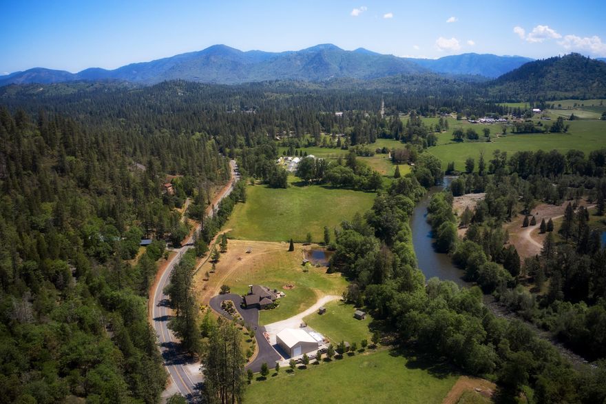 Owner Carry Possible. Welcome to Riverside Estate, a quintessential Applegate riverfront property spanning six acres with over 500 ft of river frontage. The custom home with gated entry and paved driveway provides 3339 sq ft of living space with 4 bedrooms and 3 full baths. Craftsmanship, attention to detail and pride of ownership are evident throughout the home and property. The main level has a spacious master suite, dining room, living area, grand kitchen with a large island counter, second bedroom, additional full bath and laundry room. The upper level features the additional two bedrooms, the third full bath and a bonus area. The riverfront setting can be described as a parklike setting providing a private and peaceful area for a variety of activities. The 48X48 shop has a concrete floor and  large roll up doors and a bathroom. Zoning is Exclusive Farm with irrigation rights and a permitted pond. A young grove of fruit trees provide a nice agricultural component to the property.