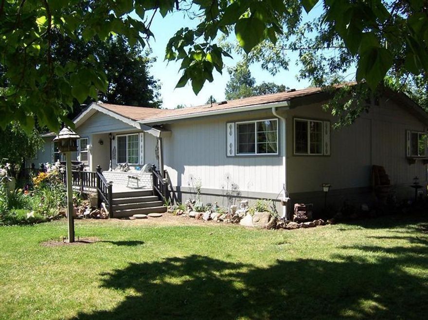 PARK LIKE SETTING!! Pride of ownership shows in this meticulously maintained 3 bedroom-2bath (1809 sf) home situated on a level 1.90-acre site with seasonal creek frontage, completely fenced and has a gated entry. This manufactured home has been significantly updated: New engineered wood floors and new tile counter tops. Completely updated bathrooms with new plumbing and lighting fixtures, new vanities and new tile wainscoting. New raised panel interior doors, new vinyl floor coverings, new water heater, new front and rear porches, new vinyl clad windows, new interior and exterior paint. This home has a split floor plan with vaulted ceilings in the formal dining room, formal living room and family room w/ certified wood stove. Home has walk-in closets in all of the bedrooms, built-in hutch in the dining room and much more. There's a (1,600 sf) shop which includes a (560 sf) finished office/guest area with lots of possibilities. Enjoy the park like setting. Home Warranty offered