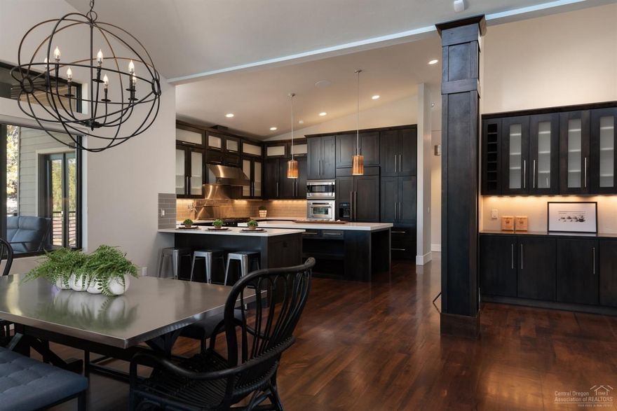 Modern luxury at the top of Awbrey Butte with Cascade Mountain views! This stunning NW Contemporary home was built by RD Construction & Design, and won 2012 COBA Tour of Homes for Best Kitchen and Best Master Suite in the $1M+ category. Master on the main provides main level living with office and private wrap around deck to soak in the snow capped mountains from your 1.6 acre estate parcel. From the soaring vaulted ceilings, ebony stained cabinetry, huge gourmet island kitchen with top of the line stainless steel Viking appliance package, complete with commercial-grade hood vent, and large walk-in pantry. Oversized 3-car garage with towering ceilings and 10' doors make this a toy lover's dream space. Downstairs you will find a second Master Suite, two additional bedrooms, bathroom, bonus room, wine cellar, and access to your private hot tub.