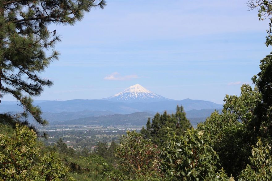 Spectacular view of the Table Rocks, Mt McLaughlin and the Valley floor from the 12 x 52 ft deck. This custom-built home is perched among the trees to take the best advantage. Bamboo wood floors, custom red oak cabinets, low e vinyl windows (including 2 garden windows) 2-year-old roof, new heat pump with an air scrubber and bluetooth Nest control. There's also a propane stove for atmosphere and a generator backup. All outside walls are load bearing; interior walls can be moved for convenient remodeling. 2nd deck on the upper level is built ready to convert into an additional room. There's an attached, finished, insulated garage and carport, large storage room and access to a high crawlspace for additional storage and 16X22 covered RV port with electricity. Need more room? There's also shop and a small utility shed located on the property.
