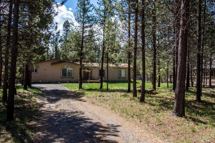 Peaceful home in the pines on a sunny, moderately treed .79 acre lot nestled at the end of a cul-de-sac . Minutes from Sunriver, Mt. Bachelor, and Bend. 4 bed/2 bath 1993 triple-wide manufactured home with vaulted great room, tiled kitchen and dining area, master with walk-in closet, utility room with sink and deck access. Enjoy the sunshine in the large, private yard. Soak under the stars in the hot tub. Oversized 2-car garage, u-shaped driveway. Lots of room for RV and all your outdoor gear.