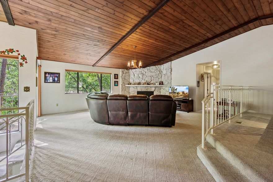 This contemporary home has been well maintained over the years and is ready for your creative vision. The vaulted kitchen and great room are open and expansive. Wood ceiling detail, skylight in the kitchen, picture window and the slider access to the deck, make both comfortable and inviting spaces, ideal for entertaining.  Main level Owner's Suite has a huge bathroom with dual vanities, tub and large shower. There are also numerous windows looking onto the low maintenance treed setting, complete with a seasonal creek. There are two additional spacious bedrooms and a full bath on the main level. The lower level features a guest bedroom, bathroom, an office and huge rec room. Surrounded by high end estate properties, this home represents a great value and unique opportunity.