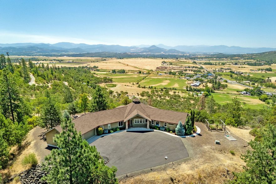 Privacy, spectacular views and a gorgeous custom home nestled amongst the trees, all tucked away on nearly 21 acres just minutes from Eagle Point and Medford! The unique architecture and quality construction of the 2,743 SF single level home does a wonderful job bringing the outdoor world in: abundant windows and natural light, soaring tongue and groove ceilings with exposed beams, hardwood floors, fir doors and trim, and an open concept that captures views throughout the home. Outside you'll enjoy extensive covered patios with additional T & G, a fenced garden, easy care landscaping and a 3-car garage. Extras include natural gas, an auto start generator, new exterior paint in 2020, new concrete coating and a strong well. The property adjoins 40 acres of landlocked BLM giving you 61 acres to explore and recreate. What an incredible opportunity to live amongst nature, enjoy abundant wildlife, and still have the convenience of town just 10 mins away! Inquire for detailed property book.