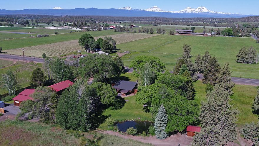 Small Tumalo acreage with huge Cascade Mountain views, beautifully restored early 1900's farmhouse, 3 acres water rights, 3 bay oversized garage with built-in storage and 9' doors and a 1300 square foot shop with extensive storage/finished offices/full bathroom. Interior features: New Oak flooring throughout main area of home; Wainscotting throughout much of the home; Remodeled bathrooms with walk-in showers; Remodeled farmhouse kitchen; Bright natural light. Exterior features: Cedar shakes and board and bat in great condition on house and buildings; Large back paver patio with large pergola; Built-in fire pit; Huge Elm trees around the property; Large Aspen groves around the property; Newer comp roof on house / metal roofing on outbuildings; Full 30amp RV hookup; Underground irrigation; Irrigation ditch running through property. RV Hookup & Parking. Easy and convenient access to Bend, Redmond and Sisters.