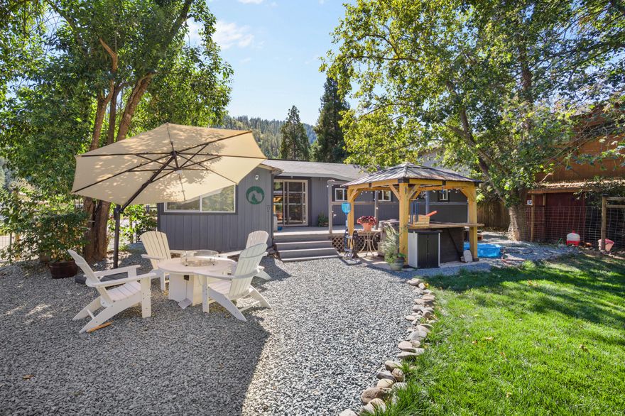 Riverfront property with private access to the Rogue, perfect for boating, fishing, and year-round fun! Inside, home has been beautifully updated and offers a cozy retreat, while outside you'll find a car charging station and Tesla solar + home battery backup for peace of mind. Two converted sheds and a storage container provide extra guest quarters with beds and TVs, offering an Airbnb-style setup. The spacious backyard is ideal for entertaining, blending comfort, sustainability, and recreation in one unique property! Amazing short term rental potential as well!