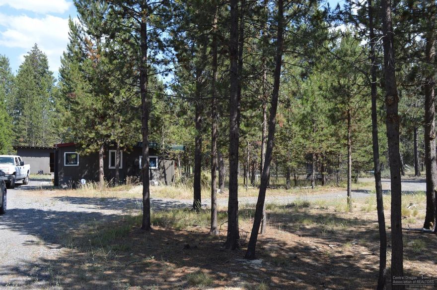 Great lot within walking distance to town. All utilities on property. Endless opportunities...you can stay in the cabin while you build or park your RV with the full RV hookups. Commercial/residential mixed use zoning. Pull through gravel driveway with gates on both sides. Call for owner willing to carry option.