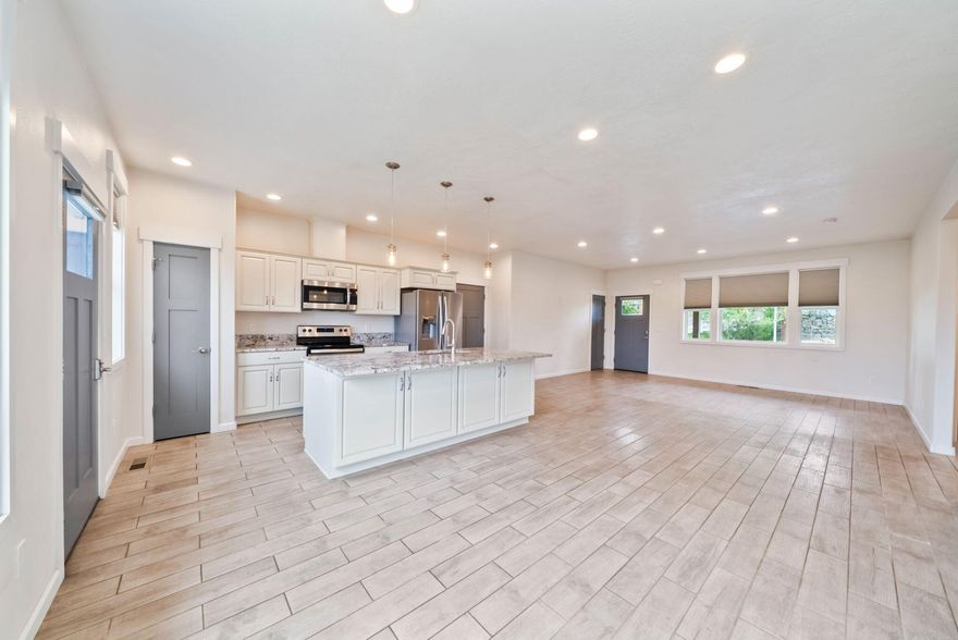 Built in 2018, this lightly lived-in, wheelchair accessible home is move-in ready! Featuring 2 bedrooms and 1 bath, it offers an open-concept design with wood-look tile floors, wide doorways, and stylish finishes throughout. The kitchen is complete with granite countertops, stainless steel appliances, and a spacious island ideal for gatherings. The bathroom includes a beautiful walk-in tile shower with custom accents and light up mirrors. Enjoy modern comforts, an oversized attached garage, and a private backyard with a patio. Located in a peaceful neighborhood—comfort, convenience, and quality all in one! Beautiful mountain views!