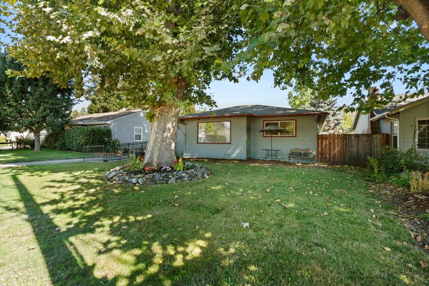 Classic Charm Meets Modern Comfort in the Heart of Grants Pass.  Step inside to discover a spacious open layout featuring wide plank laminate and carpet flooring, a well-appointed kitchen with hickory cabinets and modern appliances and abundant natural light. Primary suite has walk-in shower, large walk-in closet and slider leading out to deck and backyard.  Fully fenced back yard with deck is a blank canvas for you to make your own private oasis. The home also has a ramp to front door for easy access.  Newer roof, double pane vinyl windows, exterior paint, electrical, plumbing, HVAC and so much more.